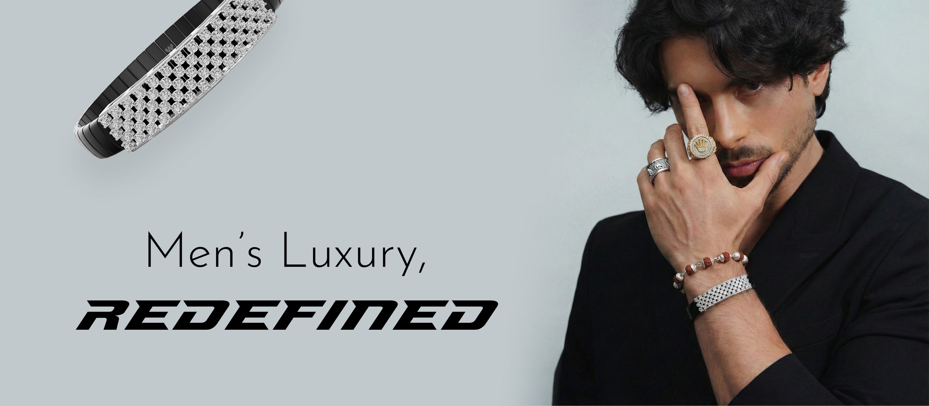 Man wearing jewelry with 'REDEFINED' branding on a gray background