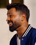 Man wearing a blue and white varsity jacket with a blurred background