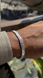 Silver bracelet on a wrist with a blurred background